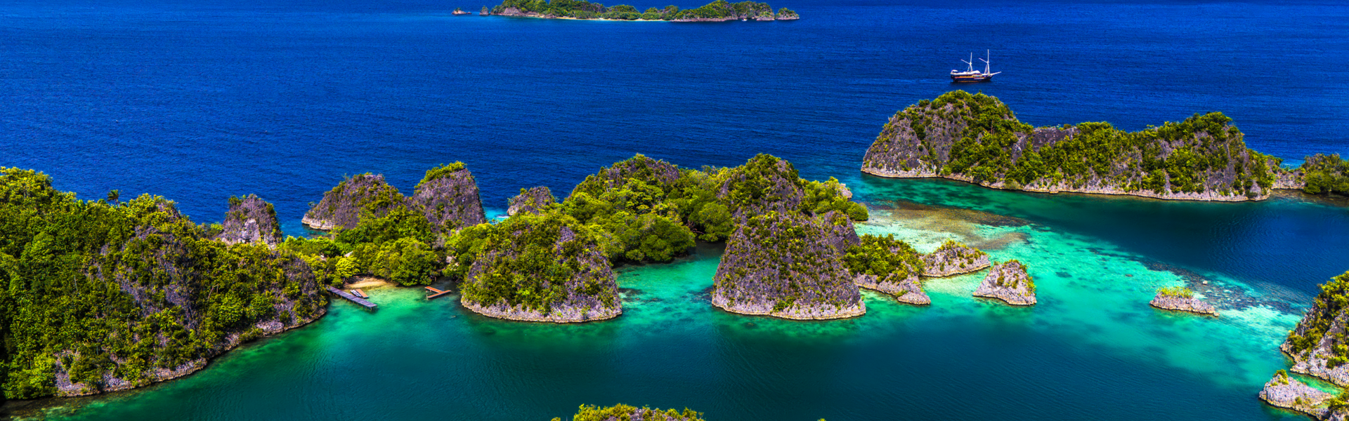 A breathtaking view of Raja Ampat, Indonesia, featuring turquoise waters, lush green islands, and vibrant coral reefs.