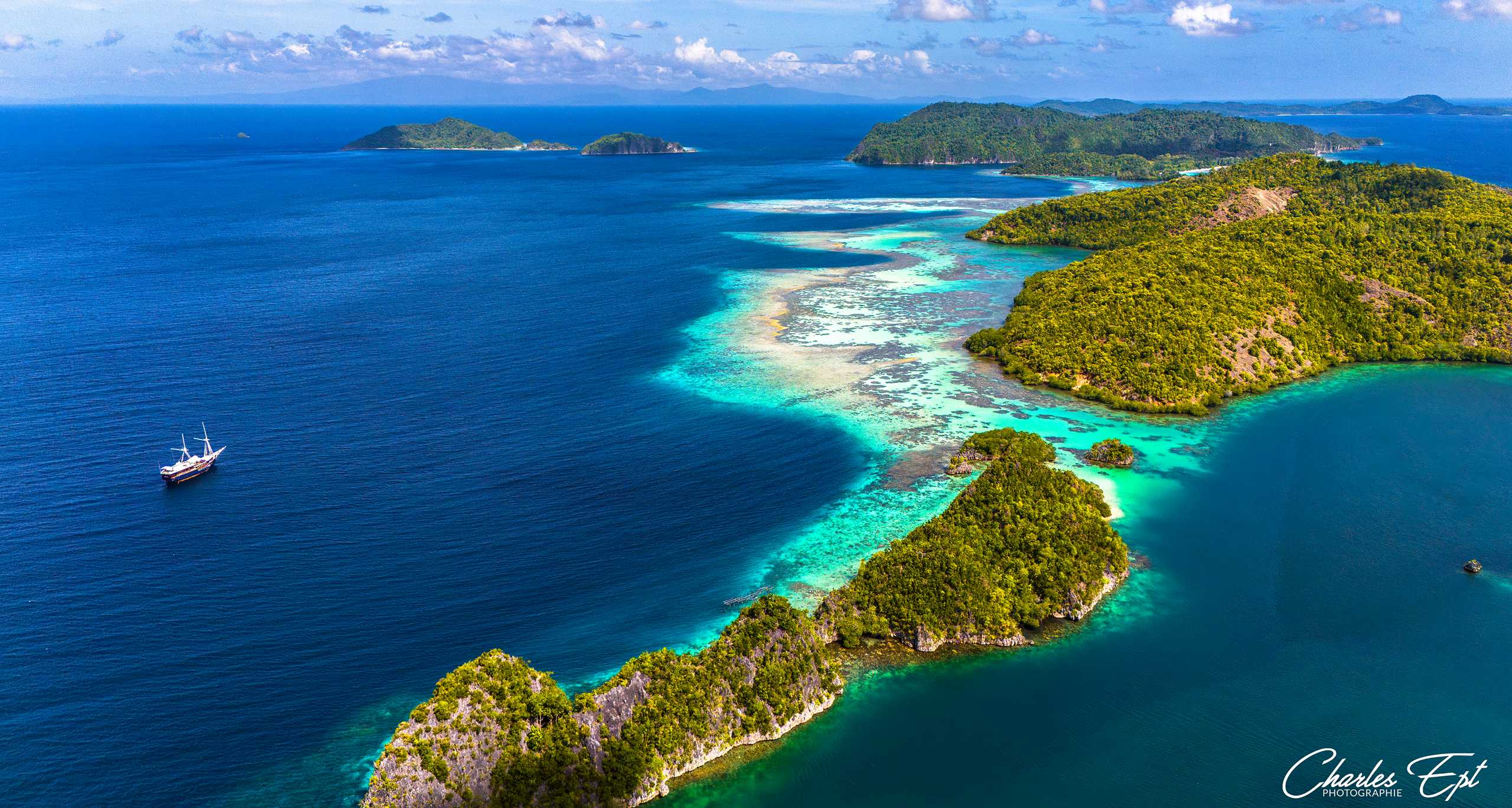 A stunning view of the turquoise waters of Raja Ampat, Indonesia, with lush green islands in the background.