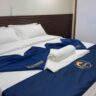 A cozy queen-sized bed cabin on the Dune Black Manta Liveaboard, featuring wooden interiors, soft bedding, and elegant lighting for guest comfort.